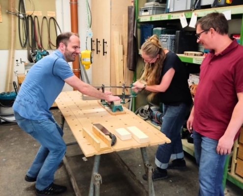 Kollegen bauen gemeinsam Holzmöbel im Teambuilding-Schreiner-Workshop