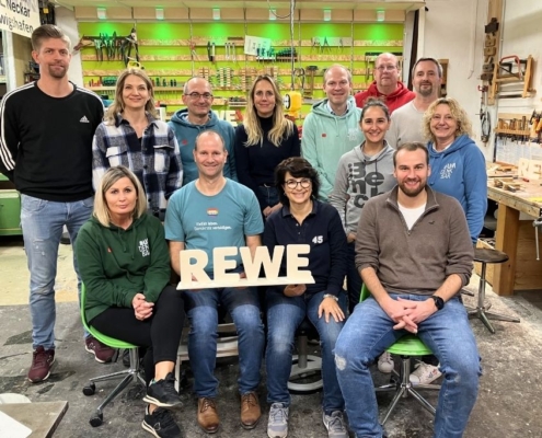 REWE-Team gruppenfoto in der Werkstatt nach dem Teambuilding-Workshop